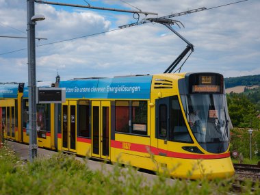 Basel, İsviçre - 7 Temmuz 2022: Şehirde toplu taşıma. Bulutlu bir yaz gününde Basel şehrinde Rodersdorf adlı tramvay istasyonunda sarı BLT tramvayı bekliyor..