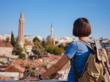 Türkiye 'ye, eski Antalya Kaleci' ye. Eski şehirde sırt çantalı mutlu Asyalı turist kadın yürüyüşçüler. Eski kasabayı ve limanı gözetleyen bir kadın var.