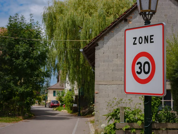 The road speed sign , village background. Speed limit sign in the country side on a summer evening.