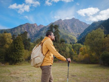 trip to Caucasus mountains, Arkhyz, Teberdinsky reserve. concept of discovery and exploration of wild places in early autumn. Man hiking in mountains with backpack and photo camera
