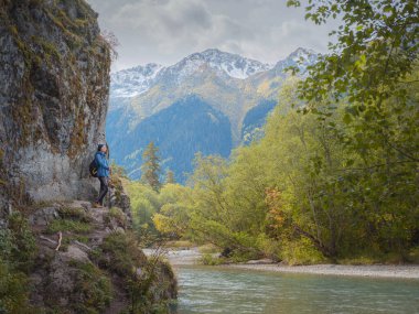 trip to Caucasus mountains, Arkhyz, Teberdinsky reserve. concept of discovery and exploration of wild places in early autumn. woman standing on the river bank