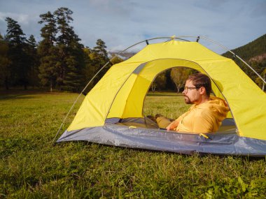 trip to Caucasus mountains, Arkhyz, Teberdinsky reserve. Man traveler relaxing in mountains in tent camping outdoor Travel adventure lifestyle concept hiking active vacations.