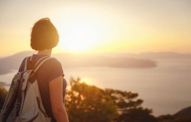 Travel to Turkey, viewpoint over Dalyan Iztuzu Beach. . Smiling woman taking break on hiking trip looking at view at sunset. Explore natural wonders of Turkey