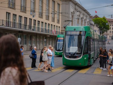 Basel, Switzerland - July 4 2022: public transport in the city. Green tram in street of Basel city center. Basels green and yellow trams have become an inseparable part of the cityscape.