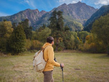trip to Caucasus mountains, Arkhyz, Teberdinsky reserve. concept of discovery and exploration of wild places in early autumn. Man hiking in mountains with backpack and photo camera