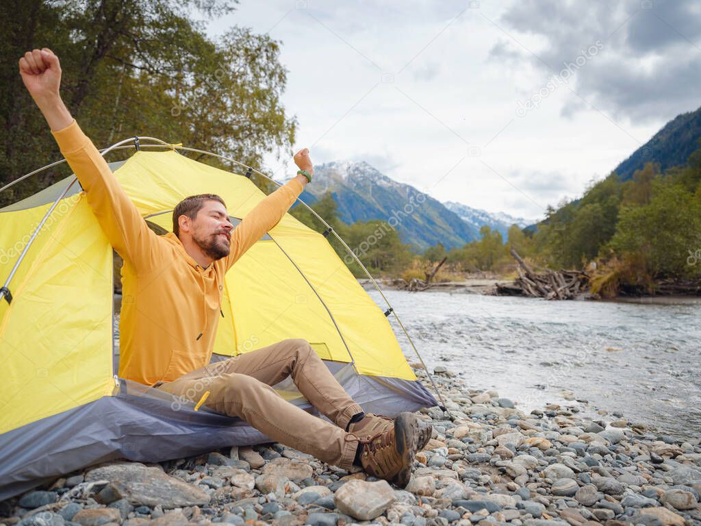 trip to Caucasus mountains, Arkhyz, Teberdinsky reserve. Man traveler relaxing mountains and river in tent camping outdoor Travel adventure lifestyle concept hiking active vacations. wake up in nature