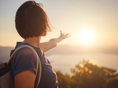 Travel to Turkey, viewpoint over Dalyan Iztuzu Beach. . Smiling woman taking break on hiking trip looking at view at sunset. Explore natural wonders of Turkey