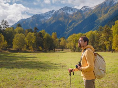 trip to Caucasus mountains, Arkhyz, Teberdinsky reserve. concept of discovery and exploration of wild places in early autumn. Man hiking in mountains with backpack and photo camera