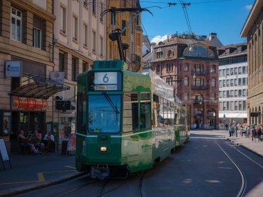 Basel, Switzerland - July 8 2022: public transport in the city. Green tram in street of Basel city center. Basels green and yellow trams have become an inseparable part of the cityscape.
