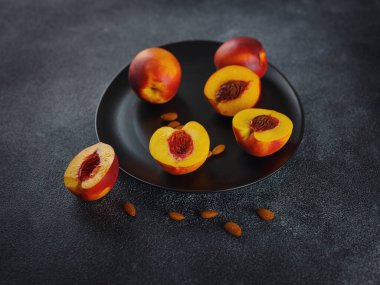 fresh sweet peaches and almond nuts on dark table. Fresh organic fruit Flat lay on old rustic background. Top view copy space