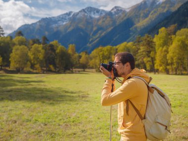 trip to Caucasus mountains, Arkhyz, Teberdinsky reserve. concept of discovery and exploration of wild places in early autumn. Man hiking in mountains with backpack and photo camera