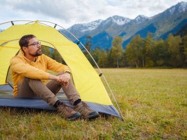 trip to Caucasus mountains, Arkhyz, Teberdinsky reserve. Man traveler relaxing in mountains in tent camping outdoor Travel adventure lifestyle concept hiking active vacations.