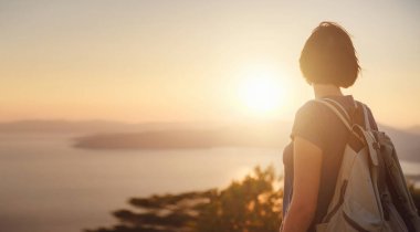Travel to Turkey, viewpoint over Dalyan Iztuzu Beach. . Smiling woman taking break on hiking trip looking at view at sunset. Explore natural wonders of Turkey