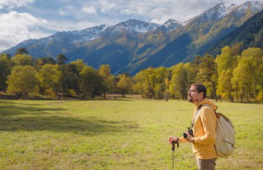 trip to Caucasus mountains, Arkhyz, Teberdinsky reserve. concept of discovery and exploration of wild places in early autumn. Man hiking in mountains with backpack and photo camera
