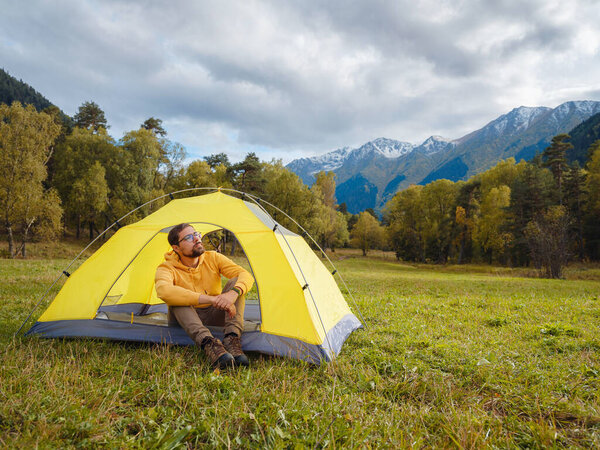 trip to Caucasus mountains, Arkhyz, Teberdinsky reserve. Man traveler relaxing in mountains in tent camping outdoor Travel adventure lifestyle concept hiking active vacations.