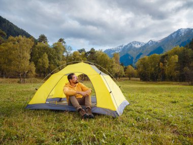trip to Caucasus mountains, Arkhyz, Teberdinsky reserve. Man traveler relaxing in mountains in tent camping outdoor Travel adventure lifestyle concept hiking active vacations.