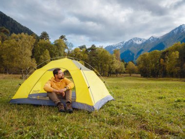 trip to Caucasus mountains, Arkhyz, Teberdinsky reserve. Man traveler relaxing in mountains in tent camping outdoor Travel adventure lifestyle concept hiking active vacations.
