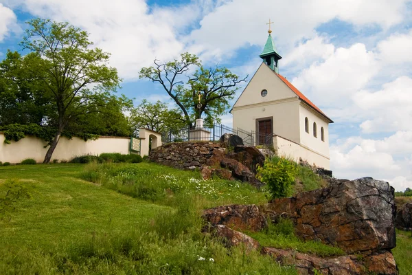 Kleine kerk met rode dak en bomen tegen blauwe hemel — Stockfoto