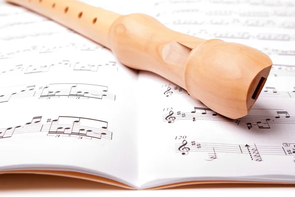 Wooden flute on sheet music. Close up. — Stock Photo, Image