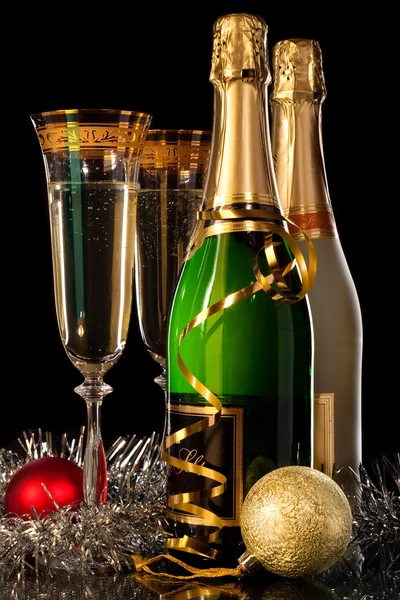 Glasses of champagne with bottles and christmas balls — Stock Photo, Image