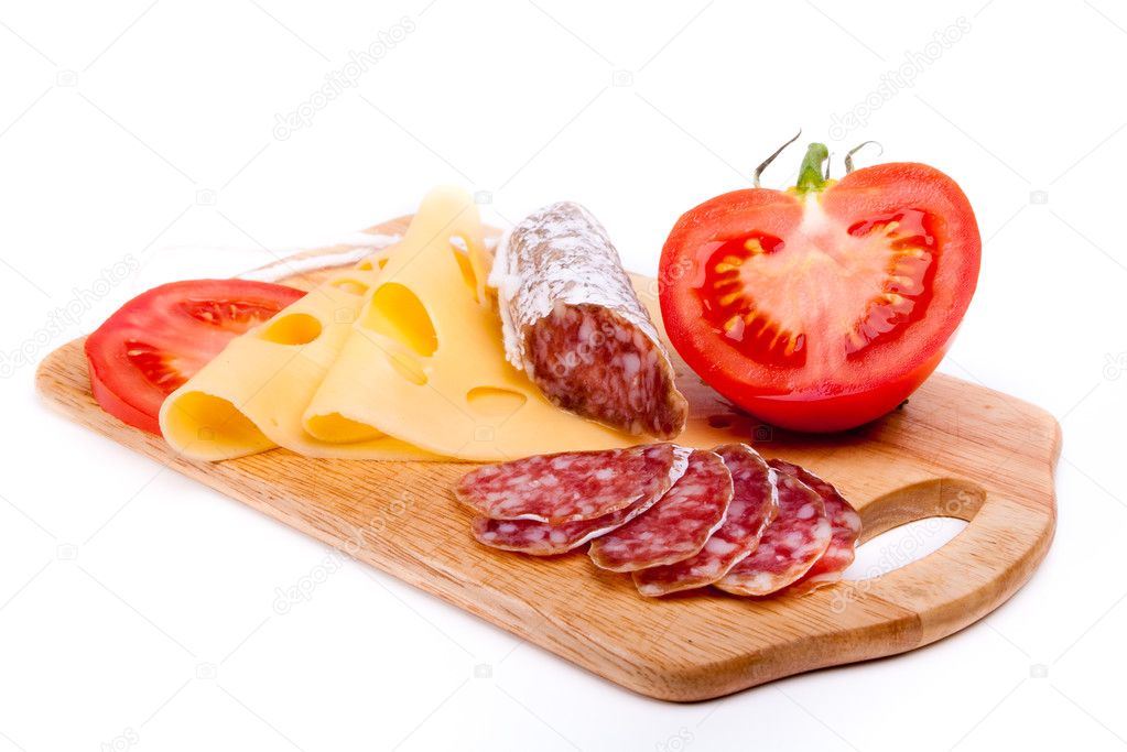 Salami, cheese and tomato on wooden board isolated on white