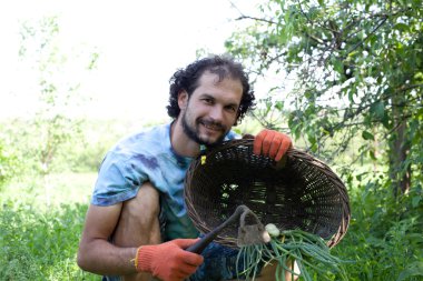 çapa ve yeşil soğan tutan adam