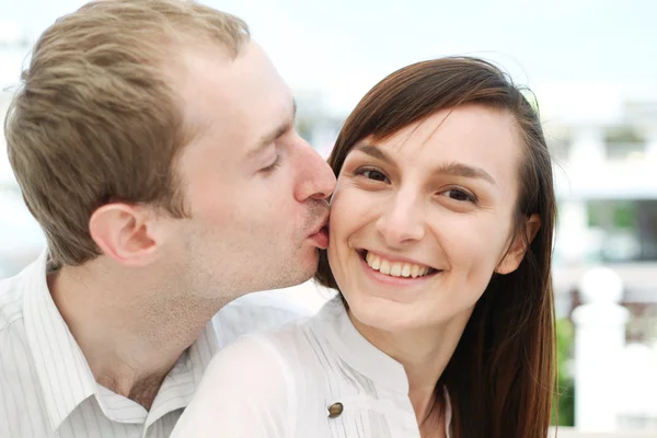 Portrait of young man kissing his girlfriend — Stock Photo, Image