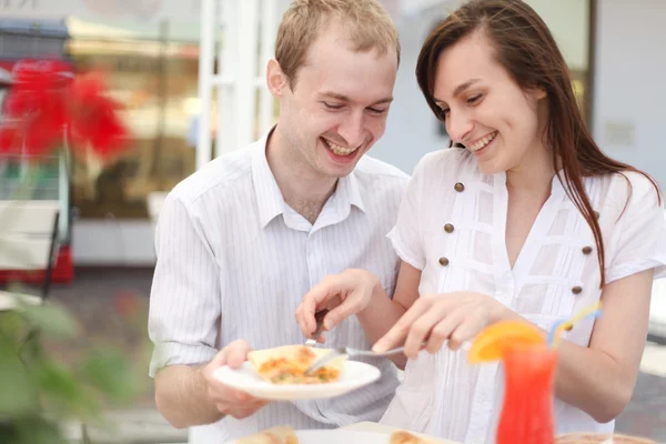 Young couple eating pizza in cafe — Stock Photo, Image