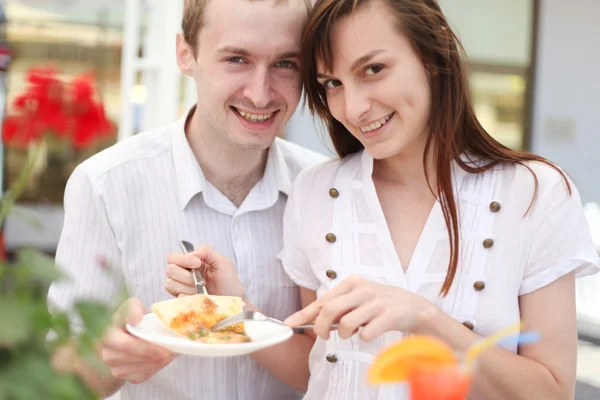 Young couple eating pizza in cafe — Stock Photo, Image