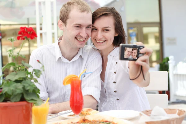 Una joven pareja tomando su foto en una cámara digital —  Fotos de Stock