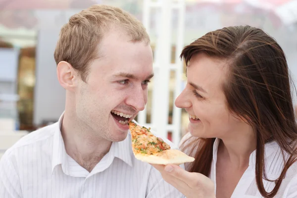 Mladý pár jíst pizzu v kavárně — Stock fotografie