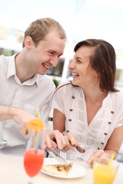 Pareja joven comiendo pizza en la cafetería — Foto de Stock