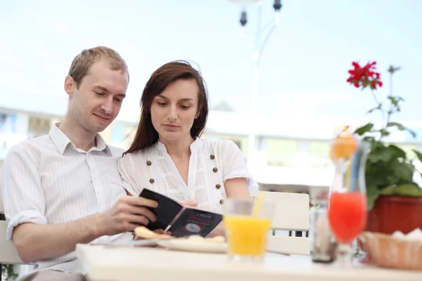 Young couple looking at menu in cafe