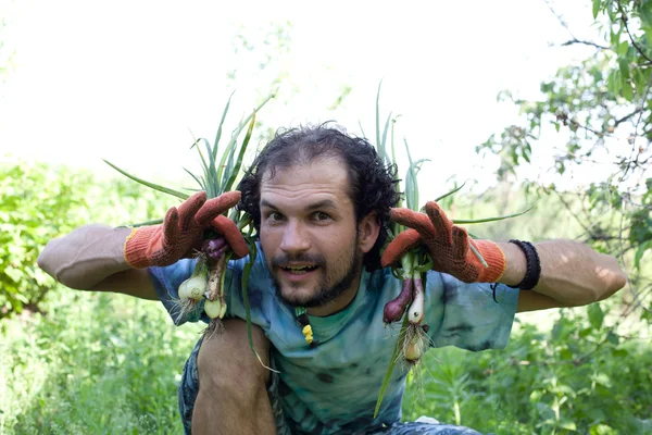 Uomo in possesso di cipolle verdi — Foto Stock