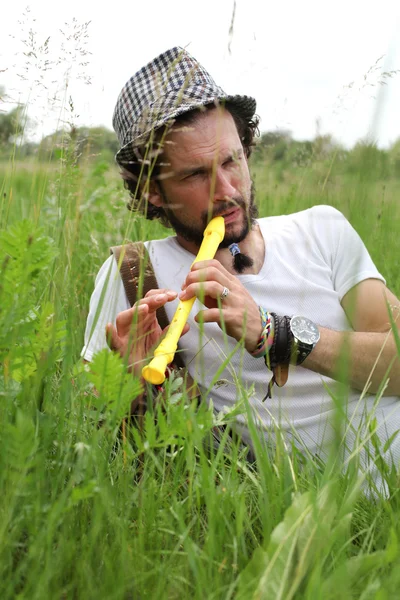 Ein Mann spielt draußen seine Flöte — Stockfoto