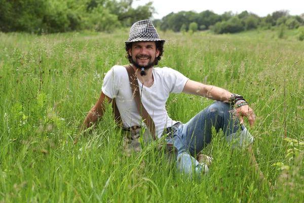 Человек, сидящий на траве — стоковое фото