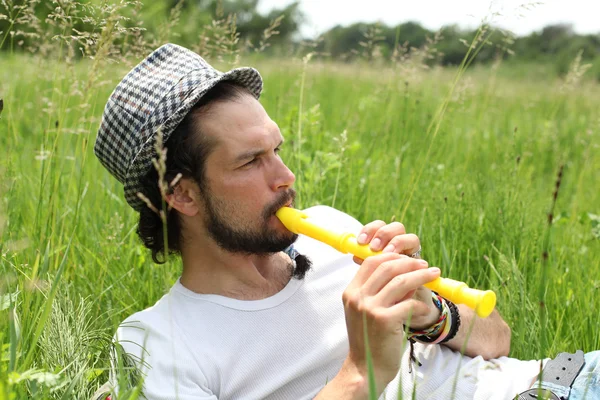 Человек, играющий на флейте снаружи — стоковое фото