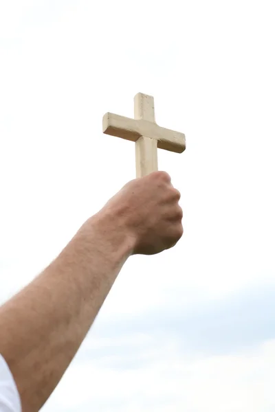 Рука з хрестом над небом — стокове фото