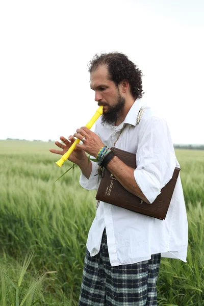 Человек играет на флейте за хороший год пшеницы — стоковое фото