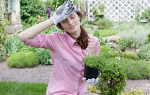 Tired woman with seedlings in the garden — Stock Photo, Image