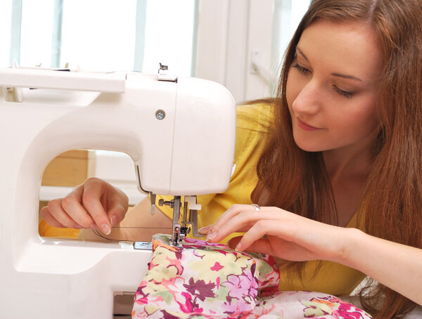 Женщина-швея работает на швейной машинке
