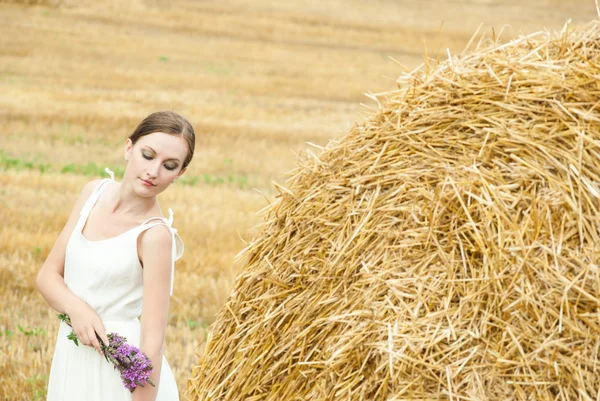 Frau auf einem Heu auf einem Feld außerhalb der Stadt — Stockfoto