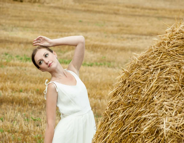 Frau auf einem Heu auf einem Feld außerhalb der Stadt — Stockfoto