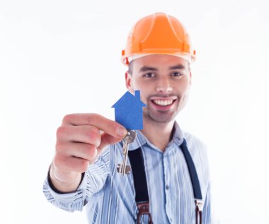 bir anahtar ve bir kağıt ev tutan bir Oluşturucu adam.