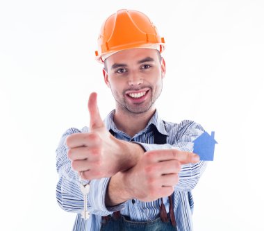 bir anahtar ve bir kağıt ev tutan bir Oluşturucu adam.