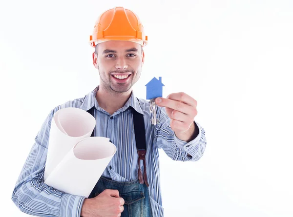 Ein Bauarbeiter mit einem Schlüssel und einem Papierhaus. — Stockfoto