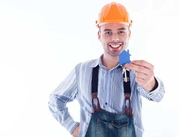 Een man van de bouwer holding een sleutel en een papier-huis. — Stockfoto