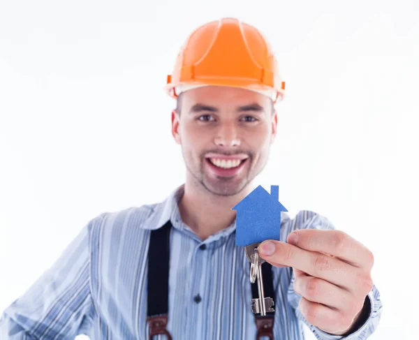 Ein Bauarbeiter mit einem Schlüssel und einem Papierhaus. — Stockfoto