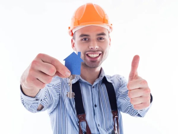 Um construtor segurando uma chave e uma casa de papel . — Fotografia de Stock