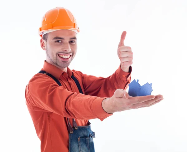 Um construtor segurando uma casa de papel . — Fotografia de Stock